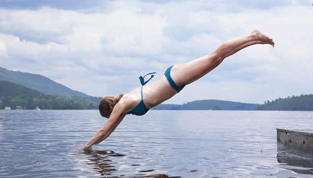 Frau macht einen Kopfsprung in den See